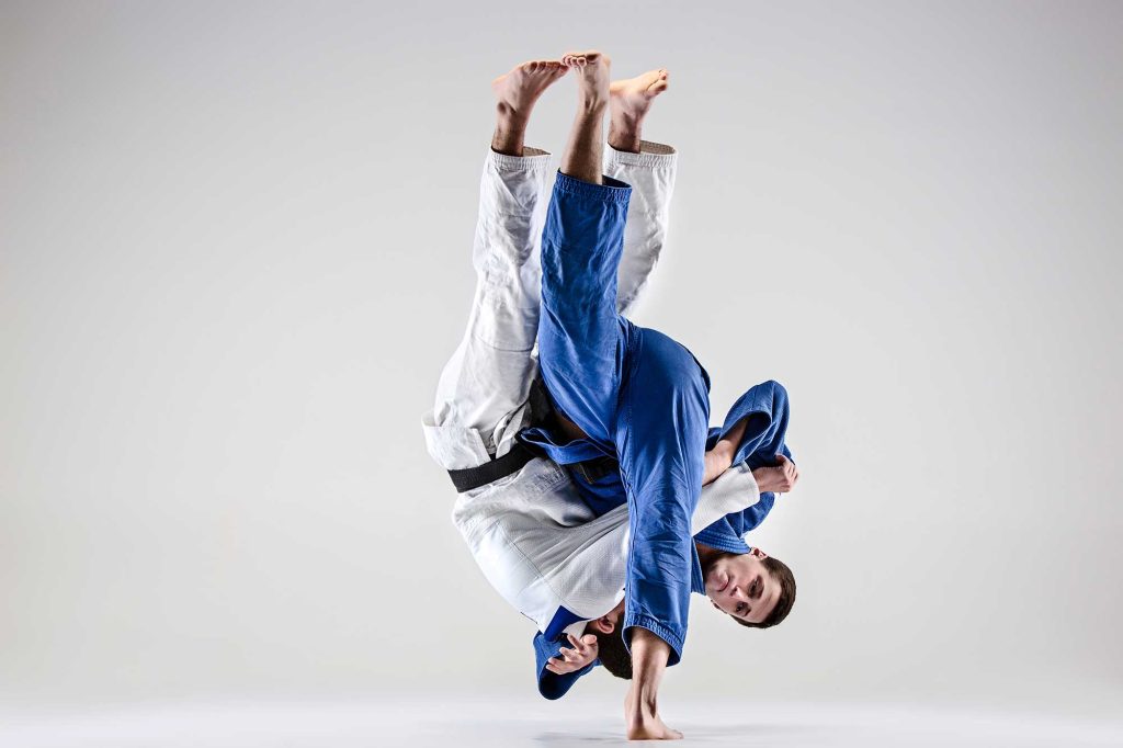 A martial artist practicing Judo throws 